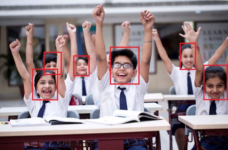 Group of excited school children cheering in classroom